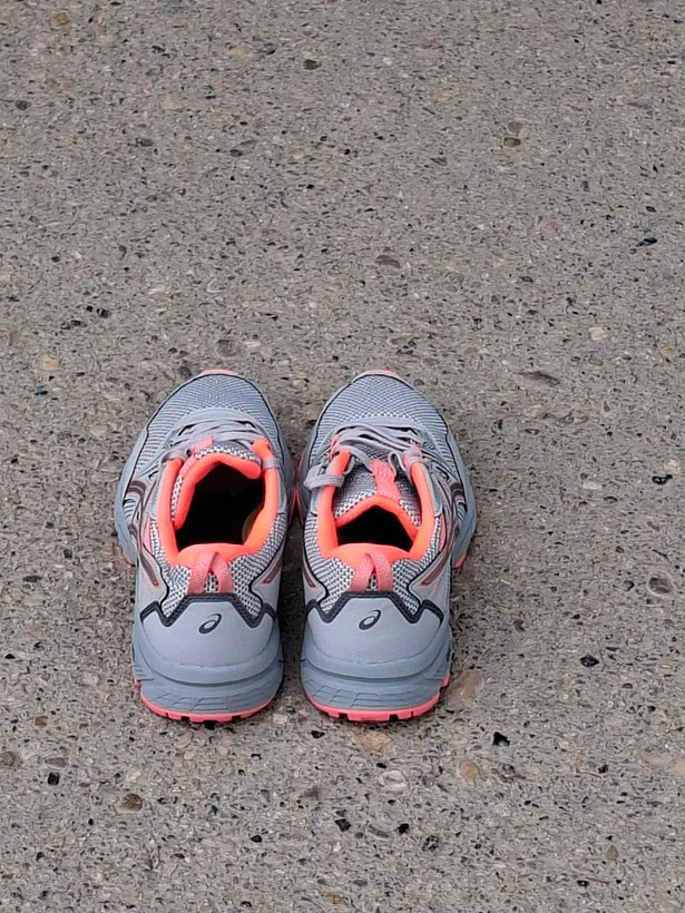 کفش رانینگ اسیکس ASICS GEL طوسی با جزئیات مرجانی، جفت کفش روی آسفالت